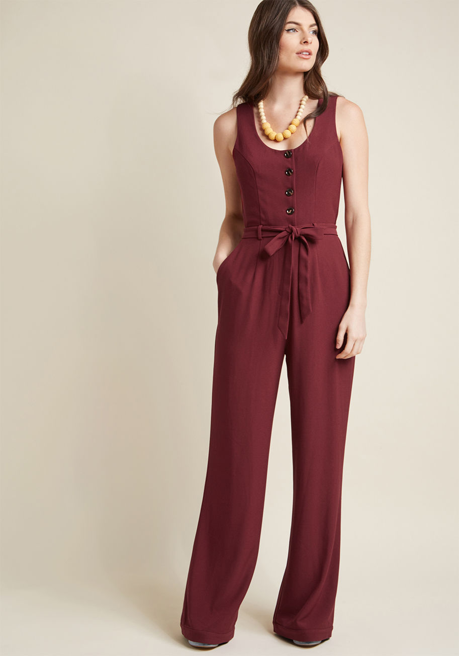 MCB1334 - This burgundy jumpsuit is sophistication at its most stylish! Tailored with princess seams and trouser-like legs, this sensational one piece offers office-ready finesse. Plus, the buttoned bodice and sash-tied waist of this pocketed ModCloth namesake labe