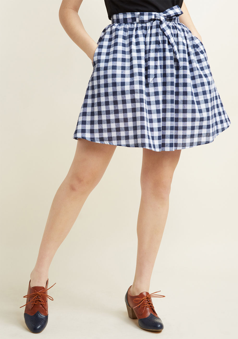 MCB1362 - When your energy comes alive with the need for exploration, bring this pocketed skirt along for the excursion! The breathable cotton blend, classic navy-and-white gingham pattern, gathered waist, and tied sash of this ModCloth namesake label lovely are al