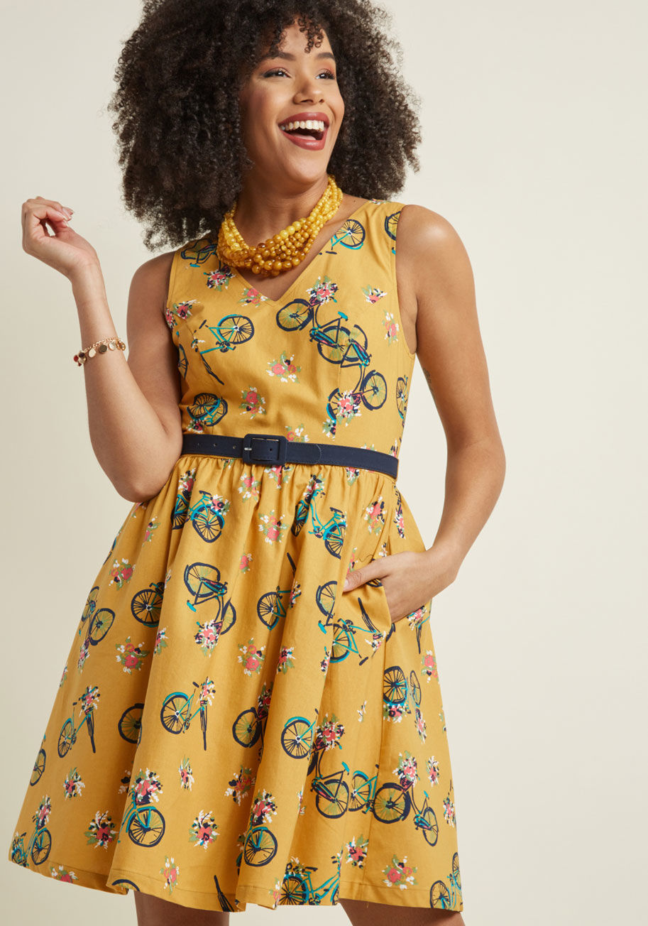 MCD1191F - You&rsquo;re not normally one to pick favorites, but this cotton dress demands an exception be made! Part of our ModCloth namesake label, this goldenrod - which boasts a V-neck, gathered waist, navy belt, and adorable print of blue bikes - stands out