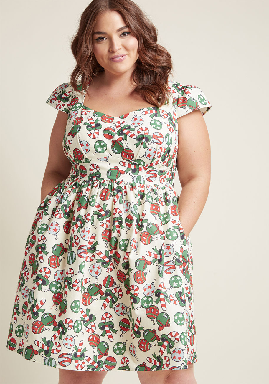 MCD1293B - This holiday dress is marvelously merry and bright! Flaunting a sweet selection of bow-top candy canes and patterned ornaments atop its vanilla hue, cap sleeves, and a sweetheart neckline, this cotton piece from our ModCloth namesake label heralds the hol