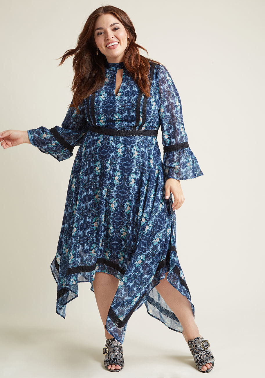 MCD1421 - While you're working on that time machine, turn to this blue midi dress to get your vintage-inspired fix! An ode to the era with its contrasting high neckline and keyhole, dark lace trimmings, bell sleeves, and handkerchief hemline, this printed chiffon n