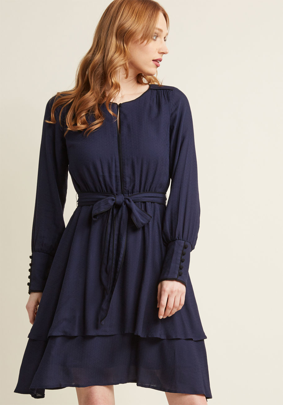 MCD1428 - As dashing as it is demure, this long sleeve dress is an above-ordinary look! Part of our ModCloth namesake label, this navy blue frock features a textured woven material, buttons down its statement cuffs, and a two tiers to its skirt. What's more, brilli