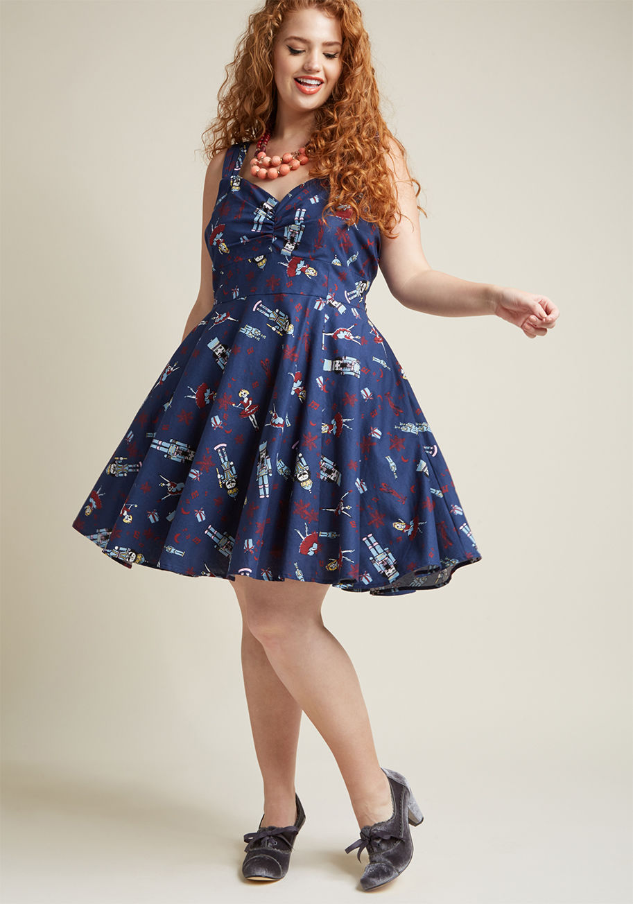 MCD1444A - When your guests finally arrive, it's hard to say what they're happier to see - the sumptuous feast, or this navy blue dress! Boasting a sweetheart neckline, ruched bust, and faux-leather belt topping its burgundy, sky blue, and ivory nutcracker print, th