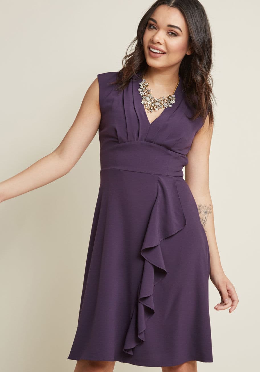 MCD1453 - There are any number of ways to accessorize this purple dress from our ModCloth namesake label, but our favorite pairing is this frock's pleated V-neck and ruffled skirt with your radiant personality! Upon this chiffon beauty's admission to your wardrobe,