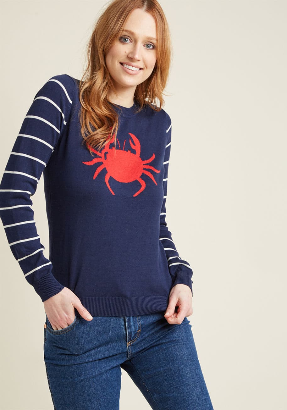 MCS1185 - This navy blue sweater from our ModCloth namesake label is for the stylista who's down to be the talk of the dock! With ivory-striped sleeves and a red crustacean intarsia, this knit pullover gives a nautical nod that'll be 'claw' the rage both