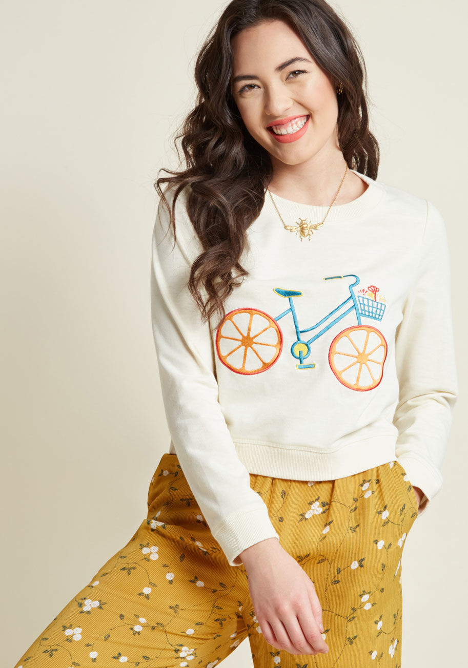 MCT1098B - What sets a garment above the rest as the ultimate ensemble option? This ivory pullover from our ModCloth namesake label is made irresistible with soft and lightweight fabric, a slightly-cropped cut, and an adorably embroidered bicycle