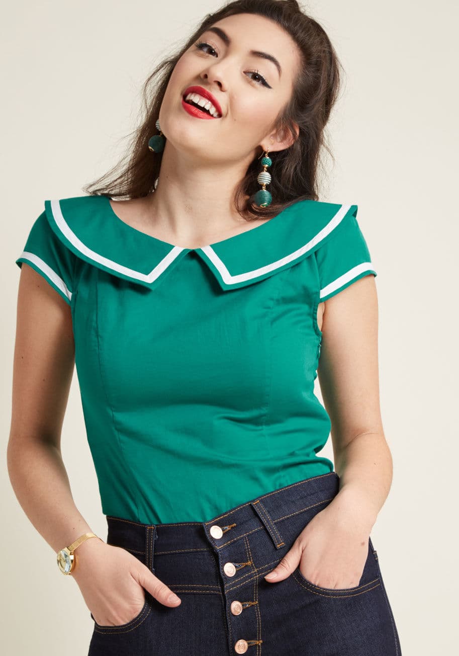 MCT1531 - If your sights are set on a retro blouse with a nautical twist, then this ModCloth namesake label top was meant to enter your radar! All set up with a jade hue, bright white trim along the sailorette-inspired collar and cap sleeves, and white, fabric-cove