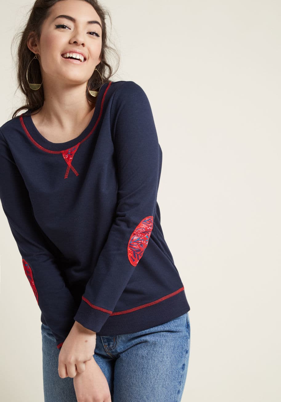 MCT1551 - Any spare moment is the perfect time to snuggle up with this navy blue pullover! An updated basic from our ModCloth namesake label, this swell sweatshirt touts patches of red floral fabric at the neckline and elbows to match its chipper stitching, making 