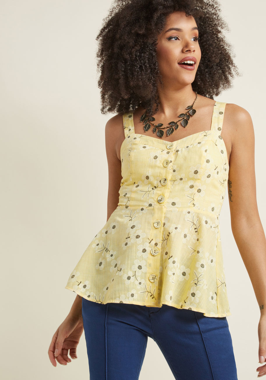 MCT1572 - When the sun is high and this yellow tank top is the center of your look, hitting up the ice cream parlor is an excellent next move! Regardless of which scoop you choose, the embroidered daisies, smocked back, and sheer peplum of this linen beauty will pa