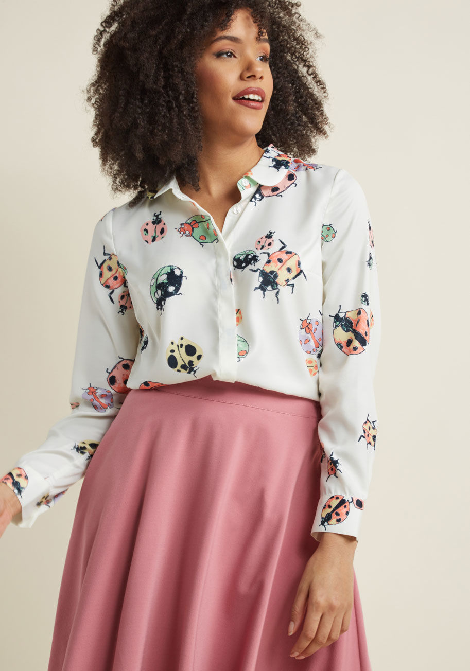 MCT1581 - Continue your legacy of flaunting unexpected elements by incorporating this ivory blouse into your wardrobe! With all the charm and quirk you've come to love from our ModCloth namesake label, this button-up top pairs a classic Peter Pan collar with a colo