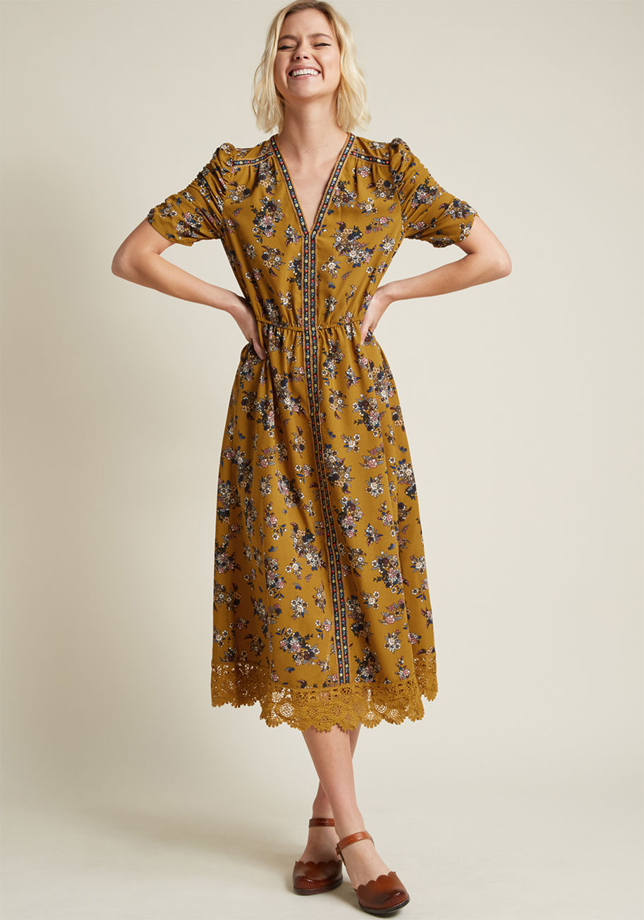 MR3172 - Anywhere you're flaunting this floral midi dress is where we want to be! Ruched at each half sleeve, trimmed at the shoulders, neckline, and down the center with a trim of embroidered blooms, and piped along the hem with lovely sheer lace, this rustic num