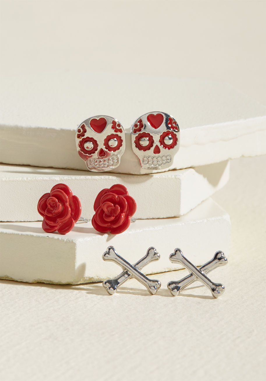 MTM05-1102 - Blend edgy elements into your beautiful style by mixing and matching these silver stud earrings! A ModCloth-exclusive trio, this set stars enamel-painted sugar skulls, red flowers, and silver crossbones, showcasing a variety of vogue motifs for all sorts 