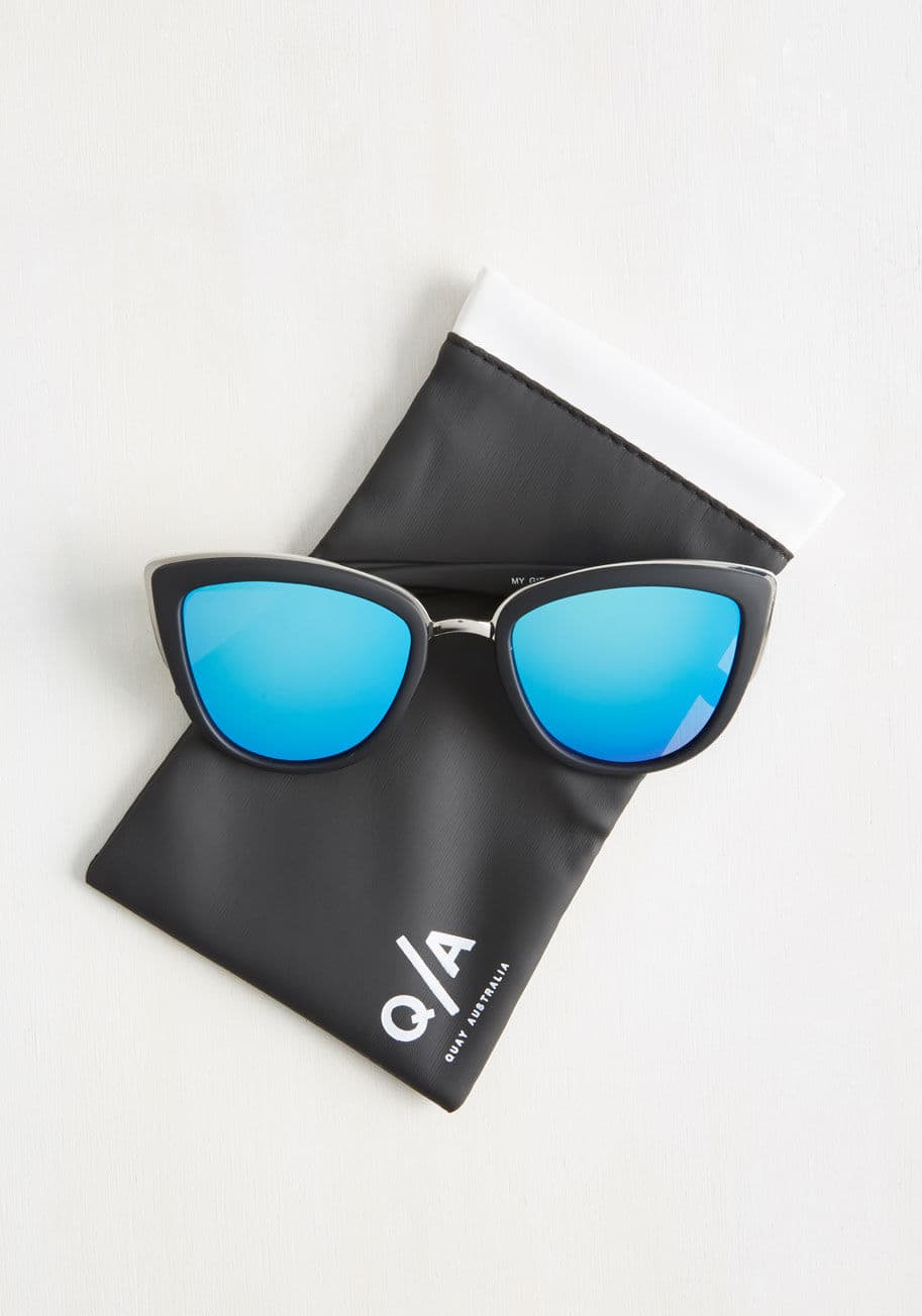 MYGIRL BLACK/BLUE - People can&rsquo;t help but ask about your My Girl sunnies from Quay Australia every time you sport them with style! Their shiny silver-rimmed, black matte frames boast vintage-inspired, cat-eye silhouettes that host reflective blue lenses for a look that