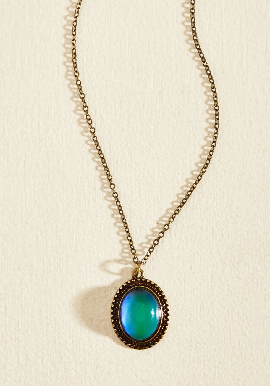 N4618 - Well, the second you clasp this pendant necklace, you will be! Starring a dark, iridescent faux-moonstone - primed to change color with your mood - this antiqued gold accessory casts a bewitching air, completing your stellar looks with spell-binding fines