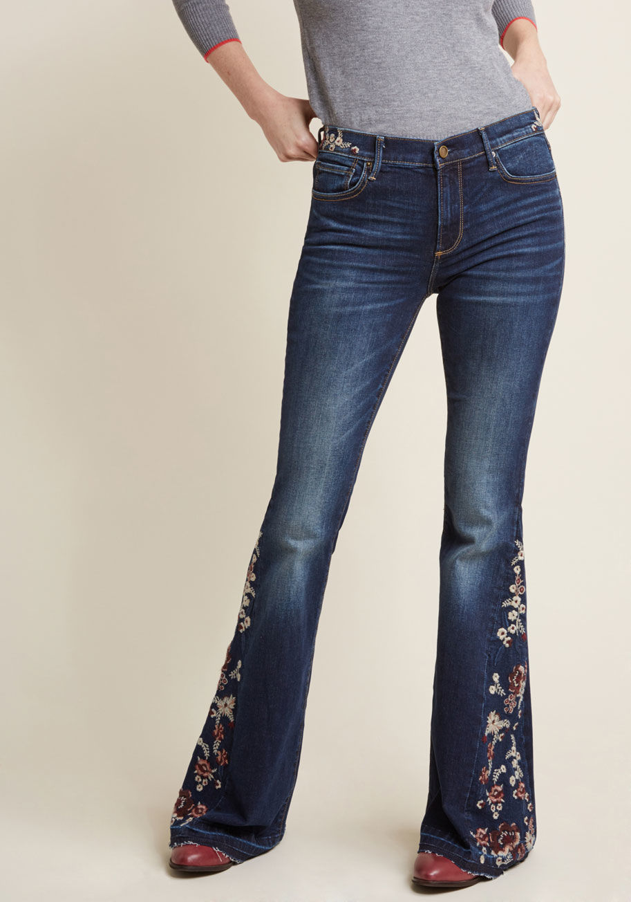 P3969A - It's impossible to hold back a smile while you're rocking these flared jeans by Driftwood! Designed to delight you with light whiskering, essential pockets, and white-and-burgundy floral embroidery at the waist and along the each leg, these beauteous bell