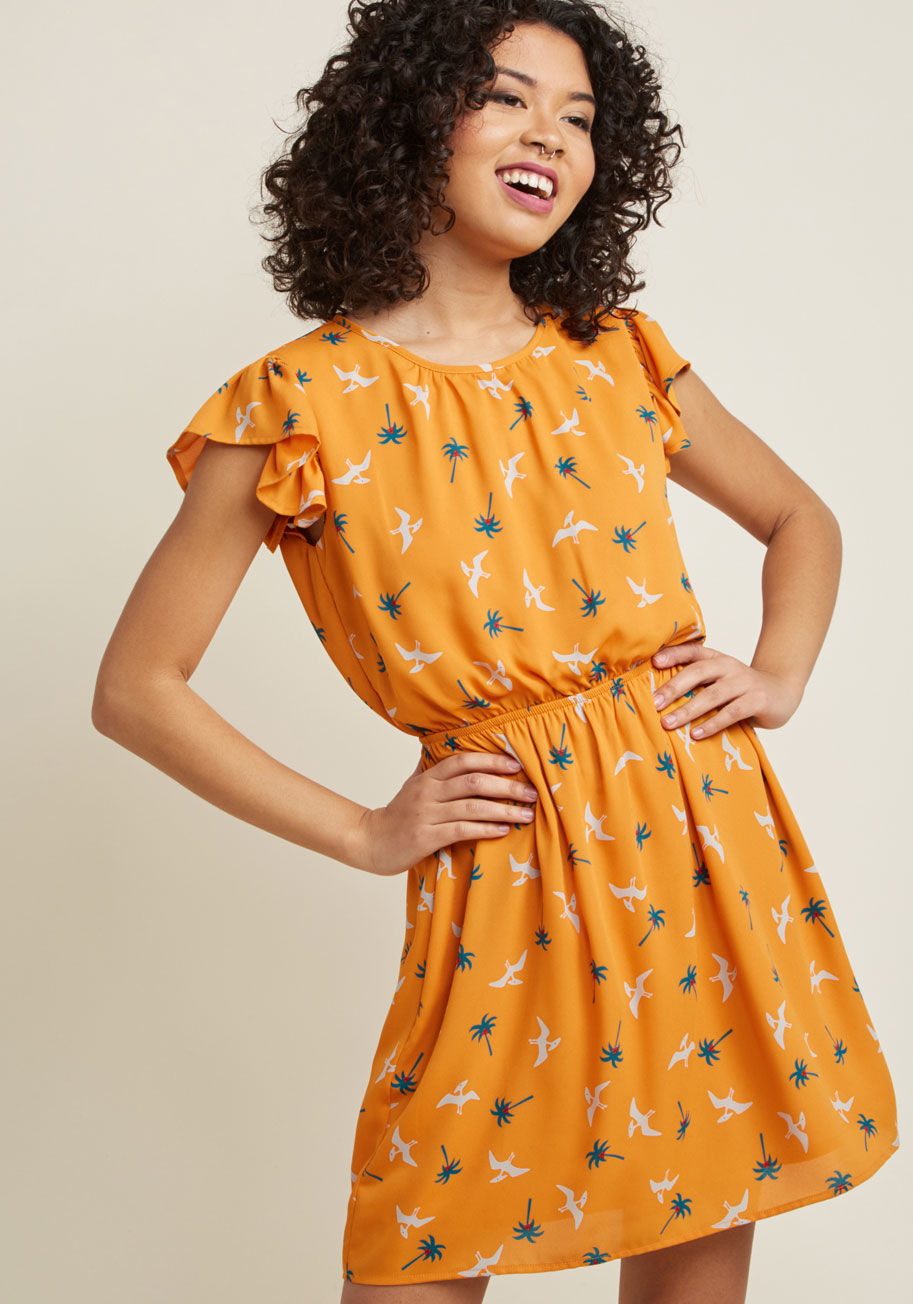 PD22383-5179 - Expressing your delight will be automatic as soon as you slip into this printed dress! A bevy of grey pterodactyls soar between teal palm trees atop this bright orange frock, adding a touch of whimsy to its fluttery short sleeves and adorably cinched wais