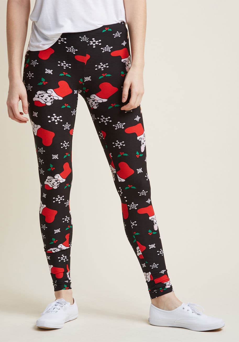 PR200848 - Guarantee a season bustling with joy by adding these black leggings to your collection of cozy clothes. Decorated with snowflakes, holly, and cats and dogs tucked into red stockings, this super-soft, stretchy pair doubles how delightful your holidays will