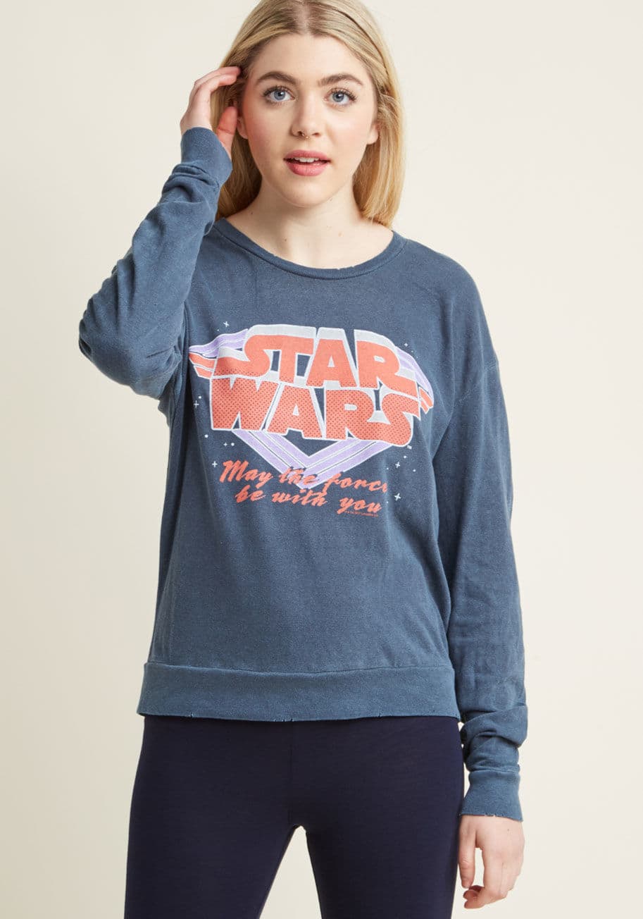 S3451-9001 - This lightweight sweatshirt - featuring an '80s-inspired spin on your favorite space opera - will soon become your number one lounging attire! Designed with a steel blue hue, broken-in distressing, and a red, lilac, and tan Star Wars logo that was given a