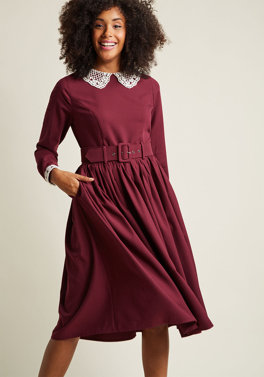 VAW170802B - Which detail of this burgundy midi dress by Collectif will you toast first? The ivory crocheting at its collar and pearl-buttoned cuffs or the convenient pockets of this perfectly tailored frock? Once you've got all this self-belted midi's features covere