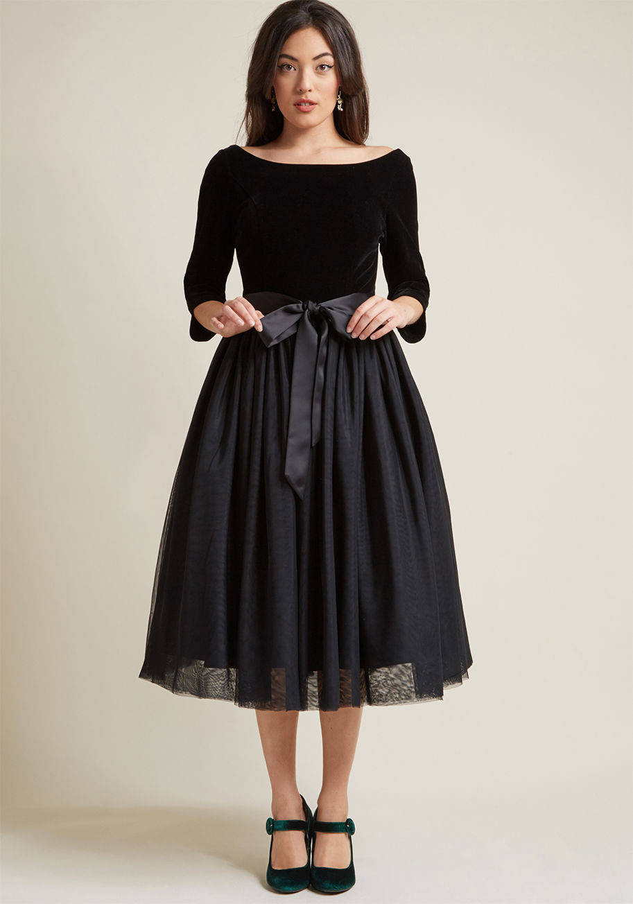 VAW170808A - This formal dress is a demonstration of how voluminous tulle equals extreme vogue! This Collectif gem comprises a velvet bodice with a bateau neckline, low back, and 3/4-length sleeves, the aforementioned statement skirt, and a satiny sash that tops the e