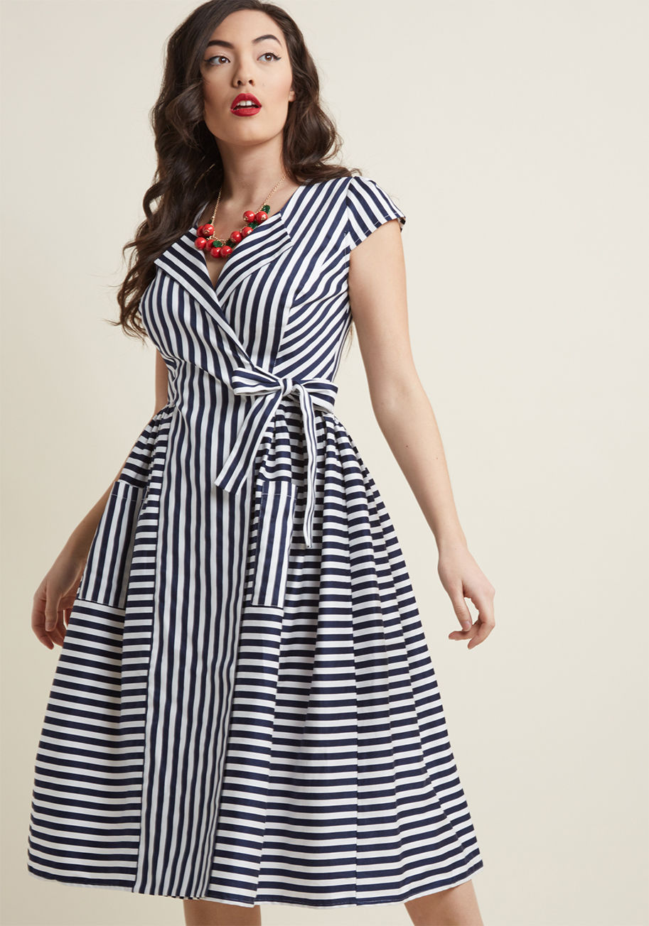 VSS180814A - A get-together with the gals for a midday meal reveals itself as the perfect opportunity to debut this retro midi dress from Collectif! Pinup sophistication emanates from the cap sleeves, chic lapels, patch pockets, and multi-directional stripes of this n