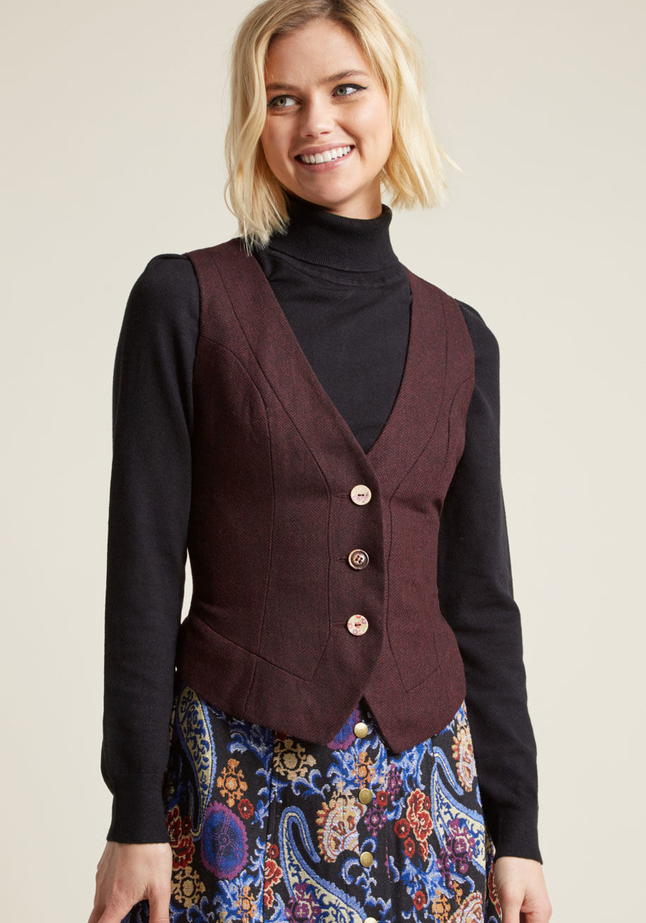 WJ099 - Looking polished on the job comes naturally with this burgundy herringbone vest as part of your ensemble! Given a steampunk-inspired spin by its mismatched buttons, paisley lining, and ribbon-laced back, this tweed vest infuses your task-mastery with pers