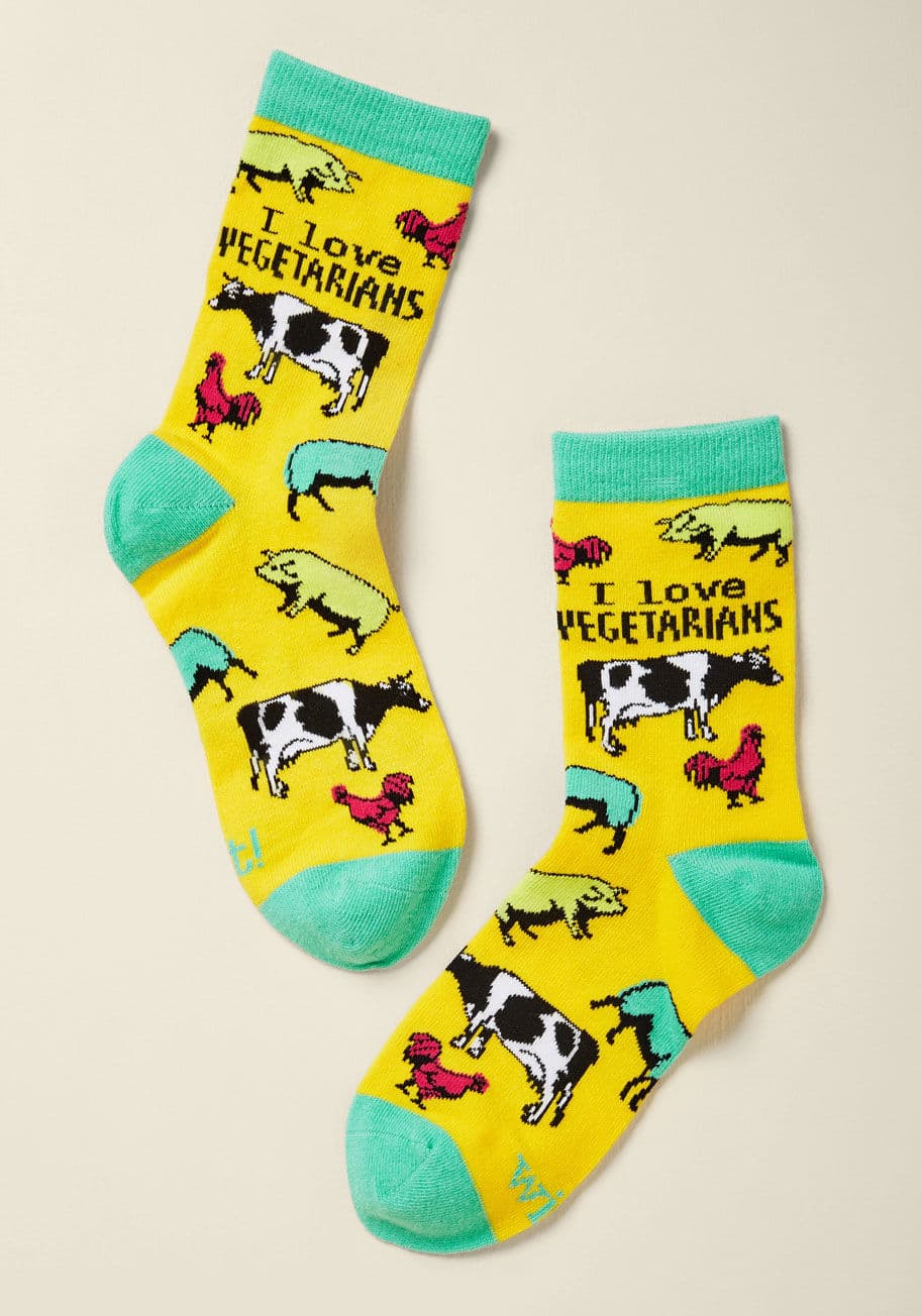 WT-1004-23 - A friend of the 'vegetable' is a friend of ours, which is why we're so amped to offer these herbivore-honoring knee socks! Brightly printed atop a bold yellow hue, off-colored animals mingle at a presumably plant-based party. Finished off with sky blue tr