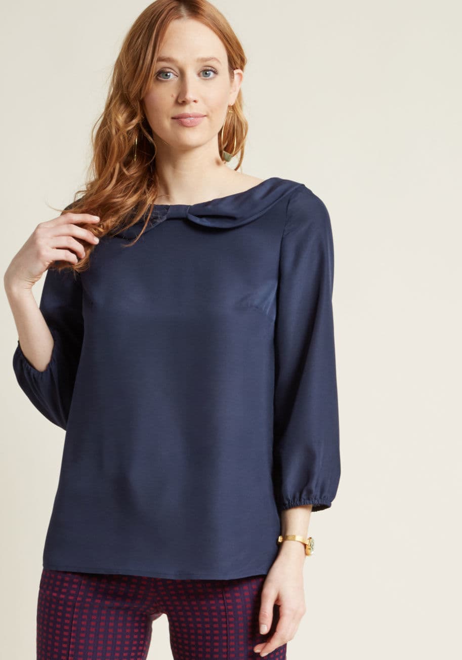 WT-1804-UK - At first glance, this navy blouse is topped with an ever-so-classic Peter Pan collar - but wait, what's this? Why, that's a darling bow detail at the neck of this ModCloth-exclusive top! Talk about a perfect pairing to the cropped sleeves and flowing fit 