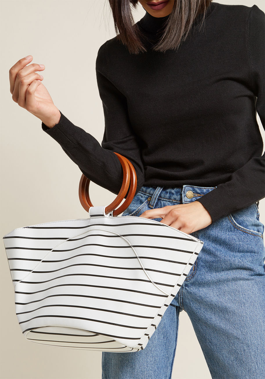 Y7308 - While loading up this faux-leather tote bag with your essentials, you can't help but feel excited about the day trip ahead! With its fan-shaped silhouette, retro round handles, and sleek black stripes atop a bright white hue, this carry-all is an excellen